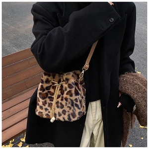 Street style shot of leopard print plush bucket bag with golden chain and pearl charm