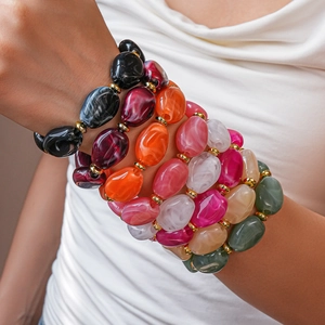 Close-up of colorful acrylic chunky oval bead bracelets with gold spacer accents