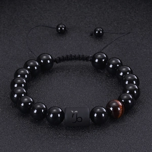 Macro detail of Capricorn bead with tiger eye stone and black agate beaded bracelet