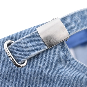 Close-up of the adjustable silver metal buckle on a light blue washed denim baseball cap