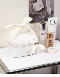 Lace texture cosmetic bag with floral jacquard detail and elegant bow handle