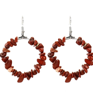 Detailed macro view of large silver hoop earrings featuring irregular natural red stones