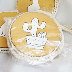 Detail of round wooden magnetic curtain tieback with white cactus pattern in packaging