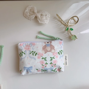 Detail of floral mini cotton pouch showing bear print and woven zipper pulls