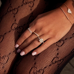 Close-up of S925 silver LOVE ring with square diamond and heart pendant on a model's hand