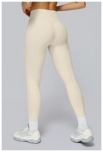 Detail of high waisted cream yoga leggings showing slimming fit and premium matte fabric
