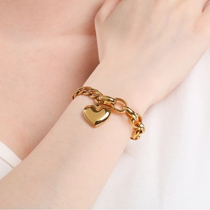 Close-up of golden 18k plated heart pendant bracelet with a stylish OT toggle clasp
