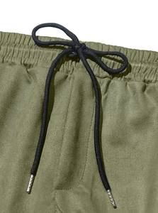 Detail view of elastic waist with black drawstring on olive green casual suit trousers