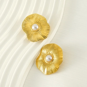 Vintage golden petal stud earrings with pearls and radial texture on white silk base