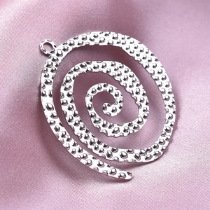 Close-up of a silver spiral pendant with hammered texture for DIY jewelry making