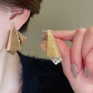 Minimalist irregular geometric gold earrings with textured overlapping triangles style