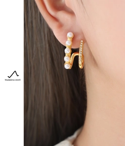 Detail of double-layer stainless steel earrings with white pearls and sparkling cubic zirconia