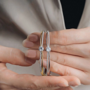 Detail of elegant gold and silver crossover bangles with pavé diamonds and round zircon stones