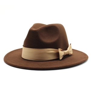 Close-up of dark brown wool felt fedora featuring a champagne gold satin ribbon bow