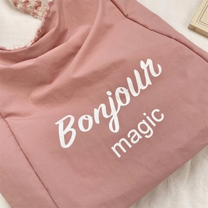 Detail of pink tote bag with Bonjour magic print and plush pink checkered strap