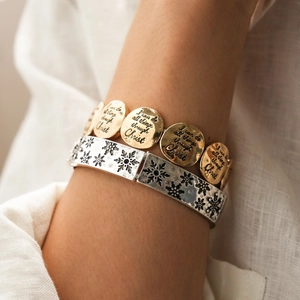 Vue détaillée du jonc flocon argenté et du bracelet doré avec pendentif religieux