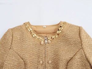 Macro detail of gold tweed jacket with sequined collar and metal zipper closure