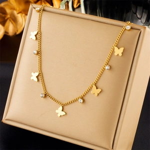 Detail of gold titanium steel layered necklace with butterfly charms and round crystals