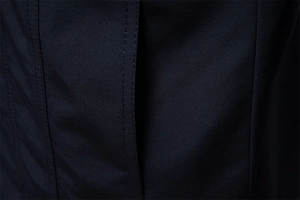 Dettaglio ravvicinato della doppia cucitura sul tessuto twill blu navy della giacca