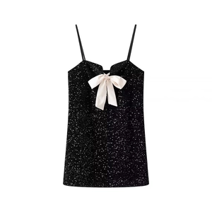 Detailed view of black sequined camisole top featuring a cream satin bow decoration