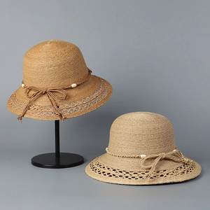 Detail von Raffia-Sonnenhüten mit hohler Webkante und eleganter Schleife mit Perlen