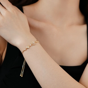 Détail du bracelet ajustable en or avec flocons en zircone porté par un mannequin
