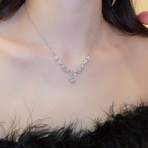 Silver necklace with zircon floral pendant worn on model with elegant black dress
