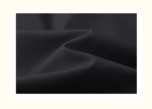 Macro shot of matte black outdoor jacket fabric showing fine texture and sleek drape