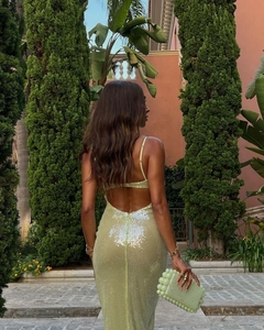 Detail of sequined backless dress in light green with a matching beaded handbag