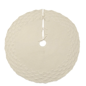 Detailed texture of ivory knitted Christmas tree skirt with hollow patterns and ribbon ties