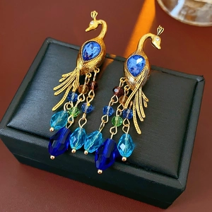 Detail of vintage peacock earrings with blue rhinestones and colorful crystal beads