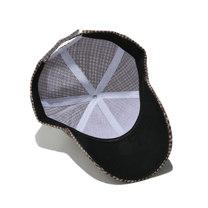 Detail view of houndstooth baseball cap with internal white seams and adjustable strap