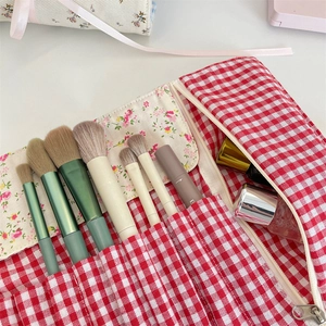 Detailed interior of red gingham and floral fabric makeup brush bag with slots