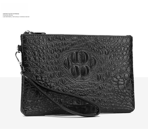 Macro detail of black crocodile embossed leather clutch with silver metal zipper closure