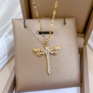 Detail of dragonfly pendant with sparkling cubic zirconia on gold stainless steel chain