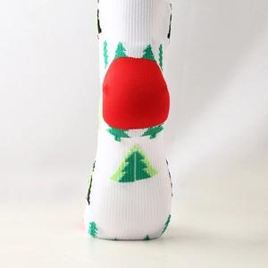 Close-up of knit compression socks featuring festive green Christmas tree patterns and red heels