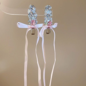 Detail of pink ribbon bow hair clips with shimmering rhinestones and tassel design
