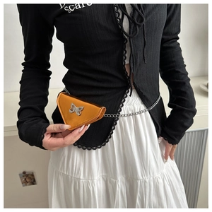 Détail du mini sac triangle orange métallisé avec papillon en strass et chaîne argentée