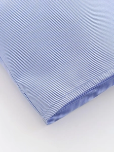 Macro view of blue and white striped poplin shirt showing precision double-needle stitching