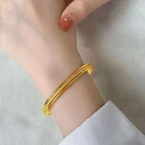 Elegant triple-layered gold bracelet featuring polished and frosted textured interlocking rings