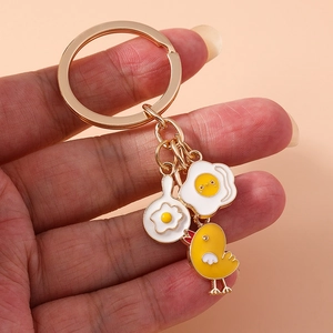Cute enamel keychain with fried egg frying pan and yellow chick charms on gold ring
