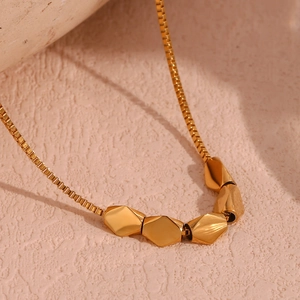 Nahaufnahme der 18K vergoldeten Edelstahlkette mit facettierten geometrischen Perlen