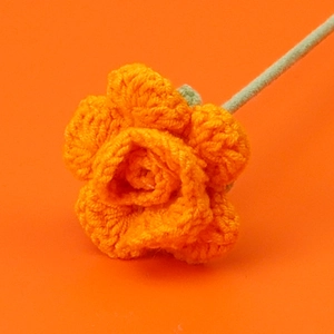 Detail of handcrafted orange crochet rose flower made of premium knit wool yarn