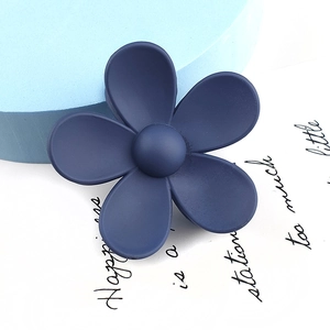 Close-up of a matte navy blue flower hair claw clip with a frosted finish on a white background