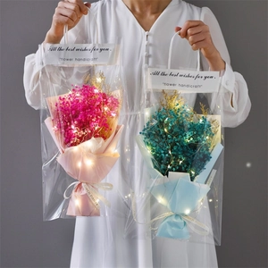 Pink and blue soap flower bouquets in gift bags with warm LED lights and ribbons