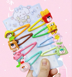 Set of 8 colorful snap hair clips with cartoon resin charms on a paper card