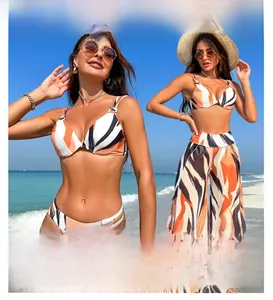 Detailed view of women's 3-piece swimwear with orange stripe bikini and sheer beach trousers
