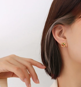 Gros plan sur les puces d'oreilles cerises carrées avec finition or 18 carats
