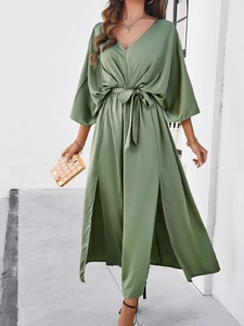 Detail showing the green silk-like maxi dress with elegant V-neck and high side slits