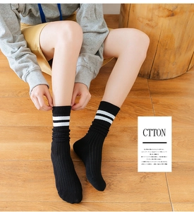 Close-up of black cotton ribbed socks with white stripes in a cozy lifestyle setting
